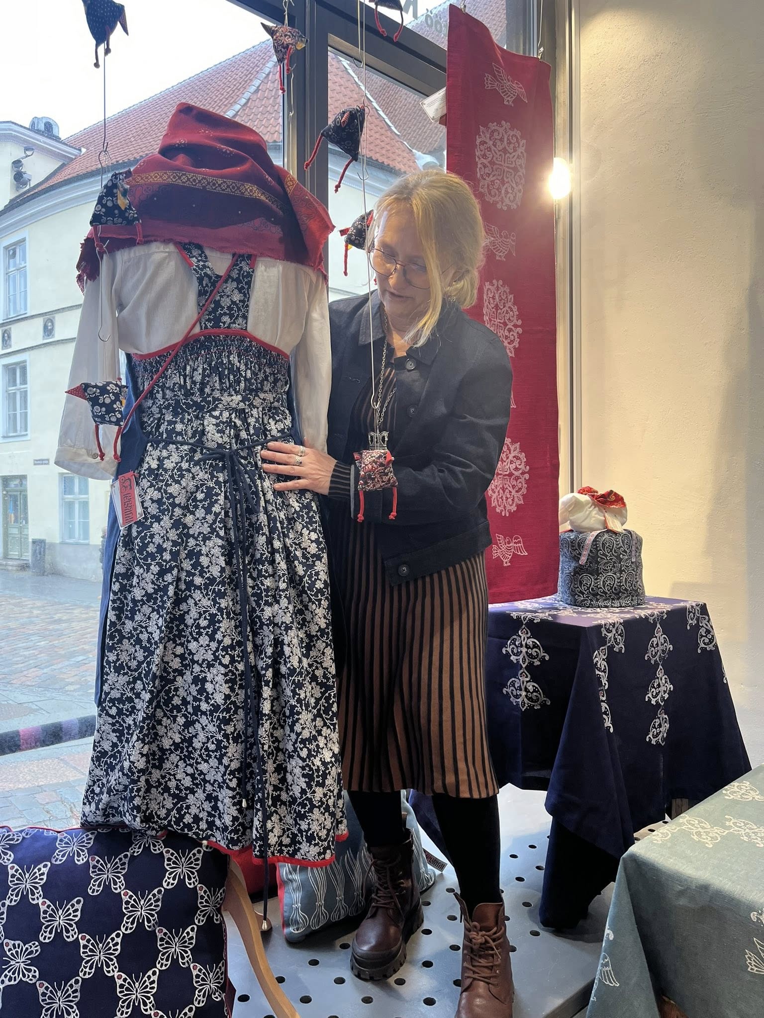Kaarmanni Käsitööpood. Märtsi aknanäitus. Peipsimaa Pärimuskeskuse sini-valgemustrilisi käsitsi trükitud kodutekstiilid ja rõivaid.